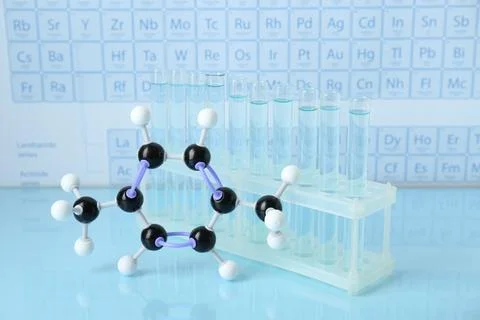 Molecular model and test tubes on light surface Stockfoto's