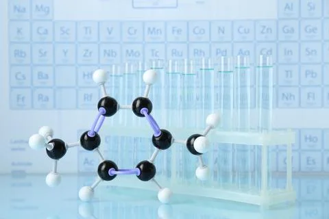 Molecular model and test tubes on light surface Stockfoto's