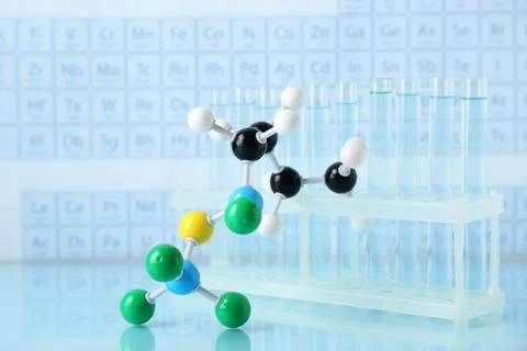 Molecular model and test tubes on light surface Stock Photos