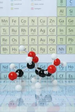 Molecular model on mirror surface against periodic table Stockfoto's
