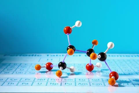 Molecular model on periodic table against light blue background Stock Photos