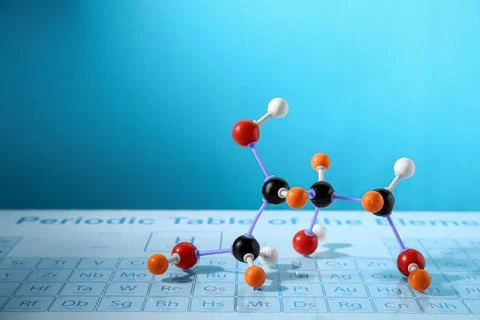 Molecular model on periodic table against light blue background, space for te 写真素材