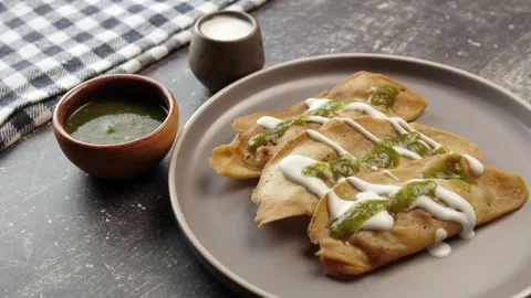 Molotes served on a round ceramic plate with cream and sauce Stock Footage 281445359