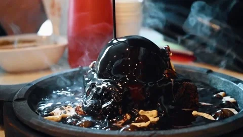 Molten chocolate being poured over the ice cream in sizzling  brownie. Stock Footage 137865543