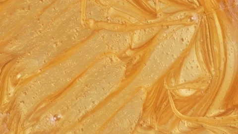Molten gold slowly slides down. Macro shot. Liquid movement with sparkles. Stock Footage 218620378