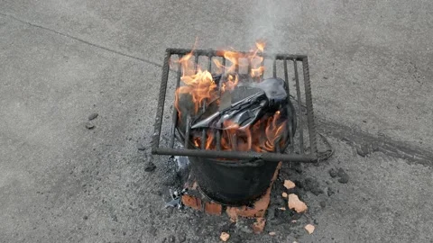Molten hot tar in bucket on bricks. Roof repair. Fire, bucket. Grid on bucket Видео 132081027