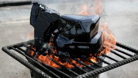 Molten hot tar in bucket on bricks. Roof repair. Fire from bucket. Grid, bucket Stock Footage 132082950