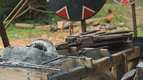 Molten metal flows from a crucible onto a prepared mold in an outdoor workshop. Stock Footage 345037013