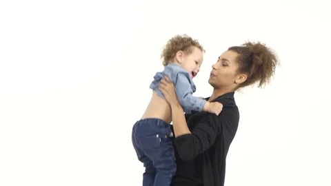 Mom of an african american throws her baby up, he likes it laughs. White Stock Footage