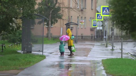 Mom and child walking in the rain Stock Footage