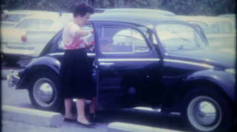 Mom and children get in their Volkswagen Bug 1950s vintage film home movie 3425 Stock Footage