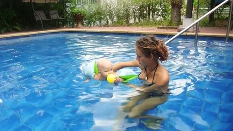 Mom and daughter are swimming in the pool in the resort. Stock Footage