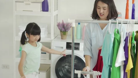 Mom and daughter doing laundry or housework chore Stock Footage 155200529
