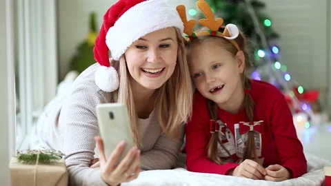 Mom and daughter  sing a song and wish Happy New Year by mobile phone Stock Footage 144563243