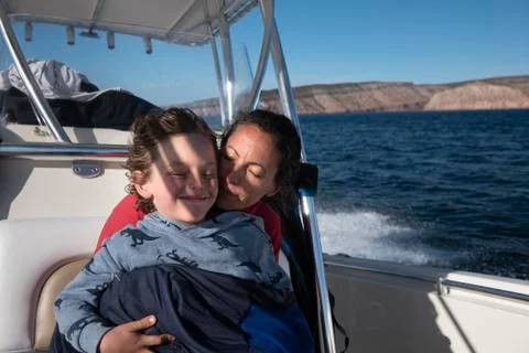A mom and her son cuddling on a sailing boat at Espíritu Santo Island. Stock Photos