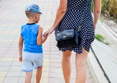 Mom and son are walking around the park in the hand. Back view. Mother in a Foto stock