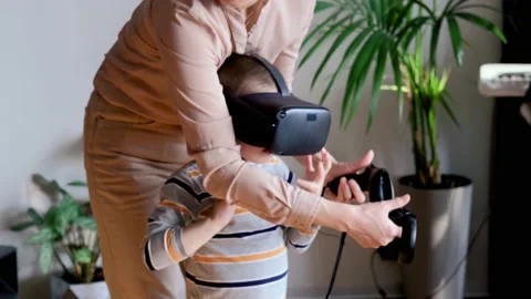 Mom and son use virtual reality glasses while playing virtual games at home Stock Footage 220075651