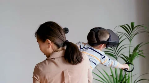 Mom and son use virtual reality glasses while playing virtual games at home Stock Footage 220336624