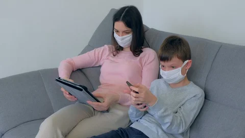 Mom and son using gadgets at home isolation on coronavirus pandemic quarantine. Video stock 128988167