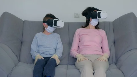 Mom and son using virtual reality glasses in coronavirus pandemic quarantine. Video stock 128982972
