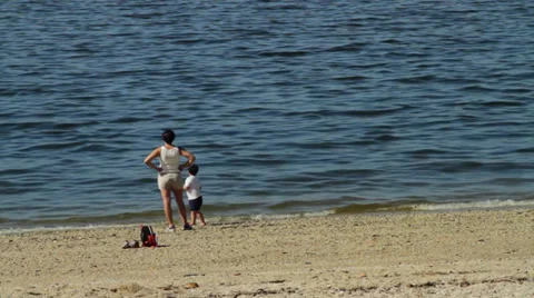 Mom and young son throwing rocks into water (4 of 4) Stock Footage 32303011