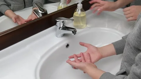 Mom assisting her kid while washing hands Stock Footage 131557633