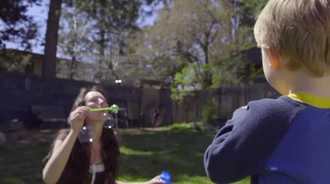 Mom blows bubbles for son Stock Footage 66527798
