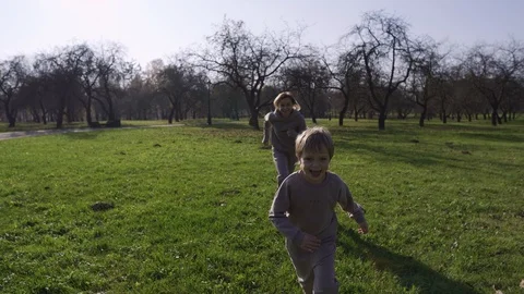 Mom With a Child Playing in the Park Catch-Up, Running Around Each Other and 스톡 동영상 118524331