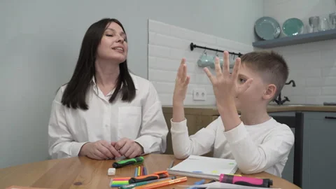 Mom comes up with a math problem for her son, the child counts on his fingers Stock Footage 258636451