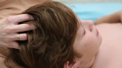 Mom is doing a head massage to her son Stock Footage 57109196