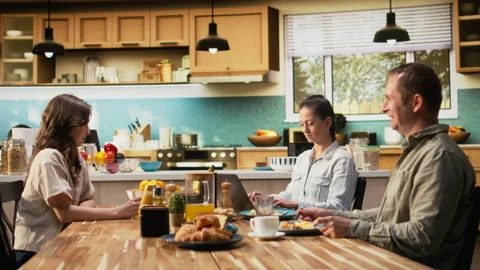 Mom doing remote work on laptop while pre-teen girl chats with his father Stock Footage 327100171