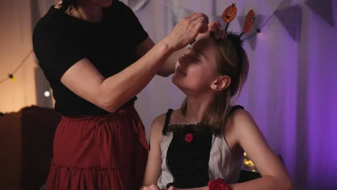 Mom Doing Spooky Halloween Makeup For Daughter Stock Footage 314011685