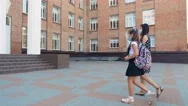Mom Escorts Daughter To School Across Schoolyard. Schoolgirl, With Backpack, And Stock Footage