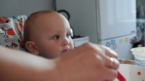 Mom feeds chubby cheeky kid soup, kid si... | Stock Video | Pond5