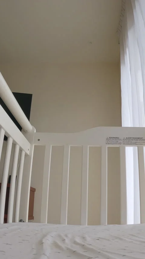 Mom gently puts her 6 months old baby boy into a crib at home, creating a calm Vídeos de archivo 345085500