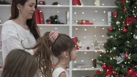 Mom helps daughters braid long hair for the new year Stock Footage 101241793