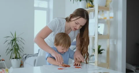 Mom helps her son to make a handprint on... | Stock Video | Pond5
