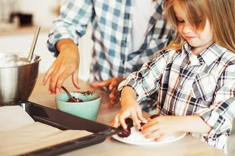 Mom with her 4 years old daughter are cooking in the kitchen to Mothers day Stock Photos