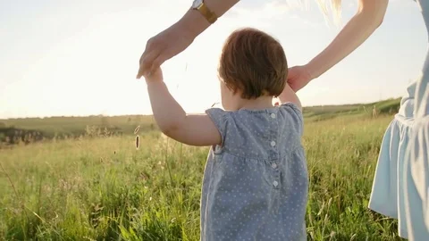 Mom holding the baby who tries to take the first steps Stock Footage
