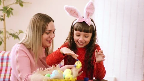 Mom holds the Easter egg, and my daughter decorates it with your fingers. Video stock 104096164