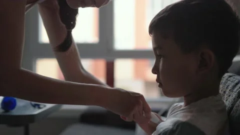 Mom inserts a thermometer into the child's armpit to measure the temperature Stock Footage 202072988