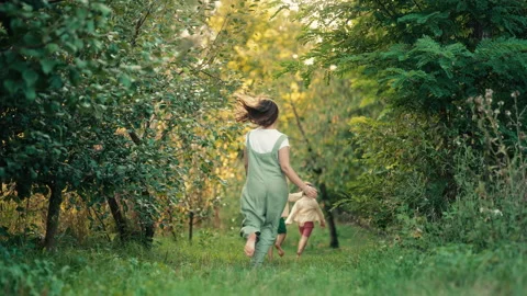 Mom, kids playing running on plot in country house. Ecological life outside city Vídeos de archivo 250815354