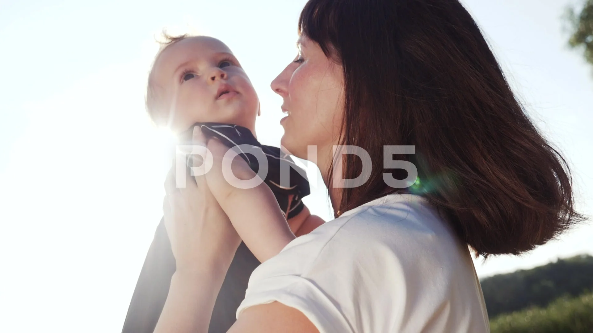 mom kiss newborn baby son holds in his arms playing in the park. mother day  kid