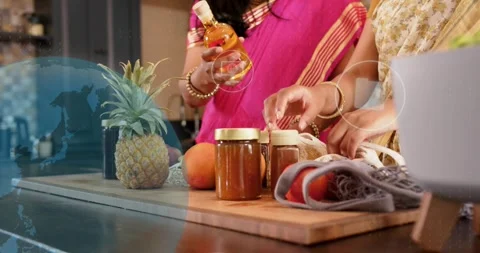 Mom lifting bottle while daughter packing jars on board, globe overlay guiding Stock Footage 321301360
