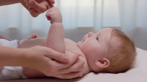 Mom massages baby's hand while smiling Stock Footage 294782260