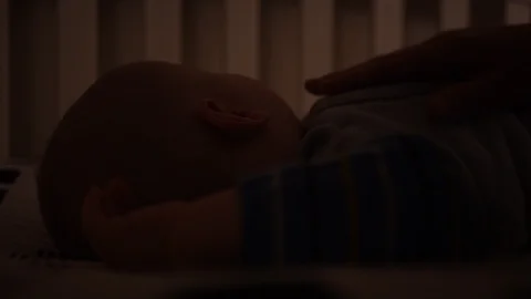 Mom patting baby back to sleep close-up Stock Footage