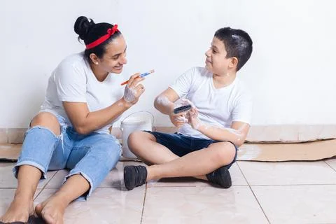 Mom playing her son while painting Stock Photos