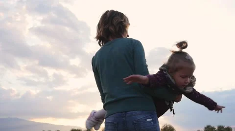 Mom playing with little child daughter on autumn meadow nature in sunset light Stock Footage