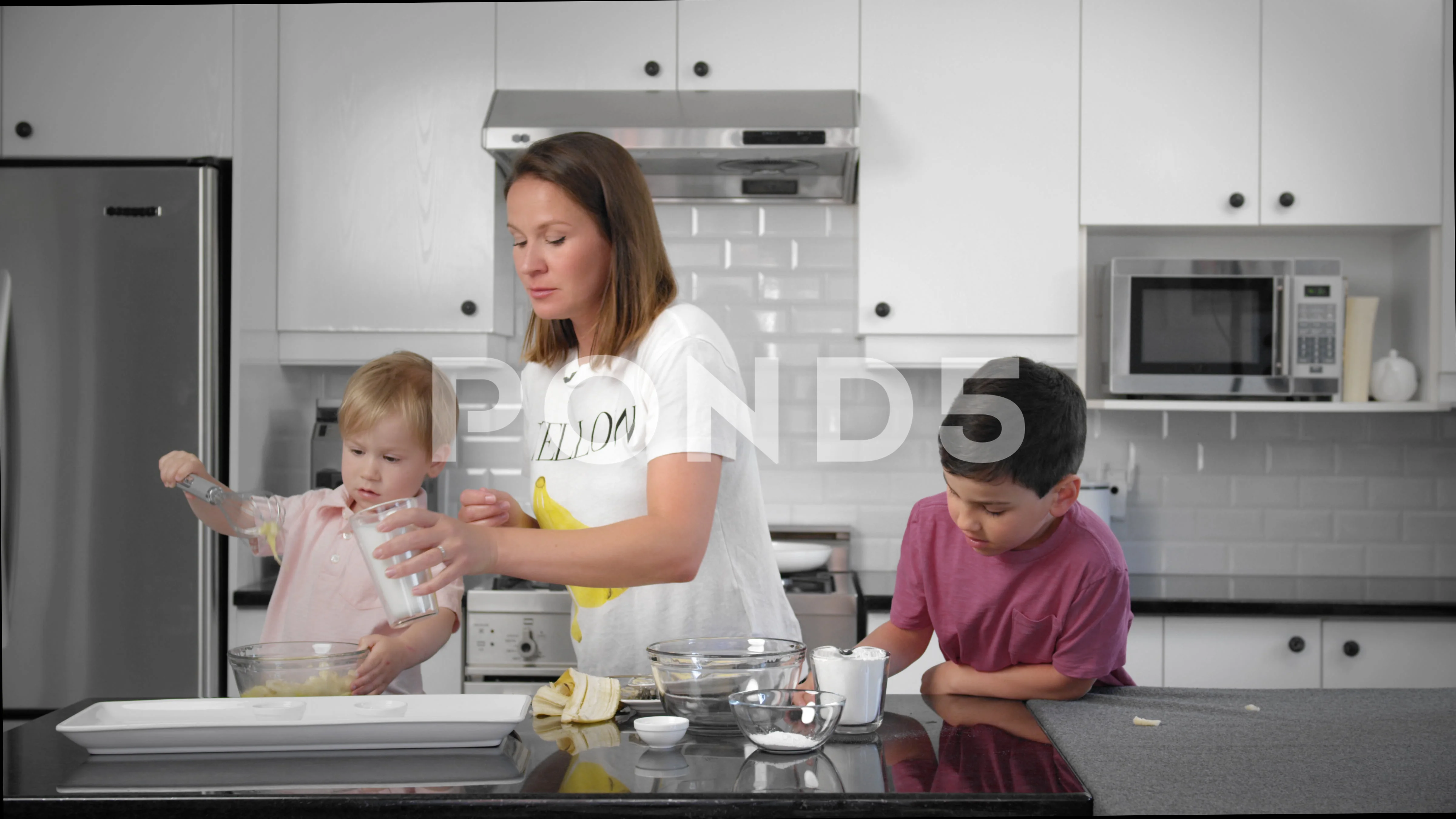 Mom is pouring milk with two boys in the kitchen. Vlog Cooking channel