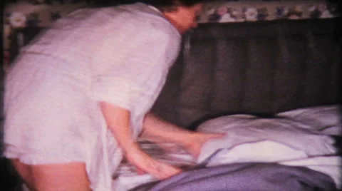 Mom pulls bed covers down and gets in 1950s vintage film home movie 1625 Stock Footage 46163081
